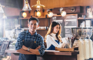 A young man and a young woman standing in their own coffee store